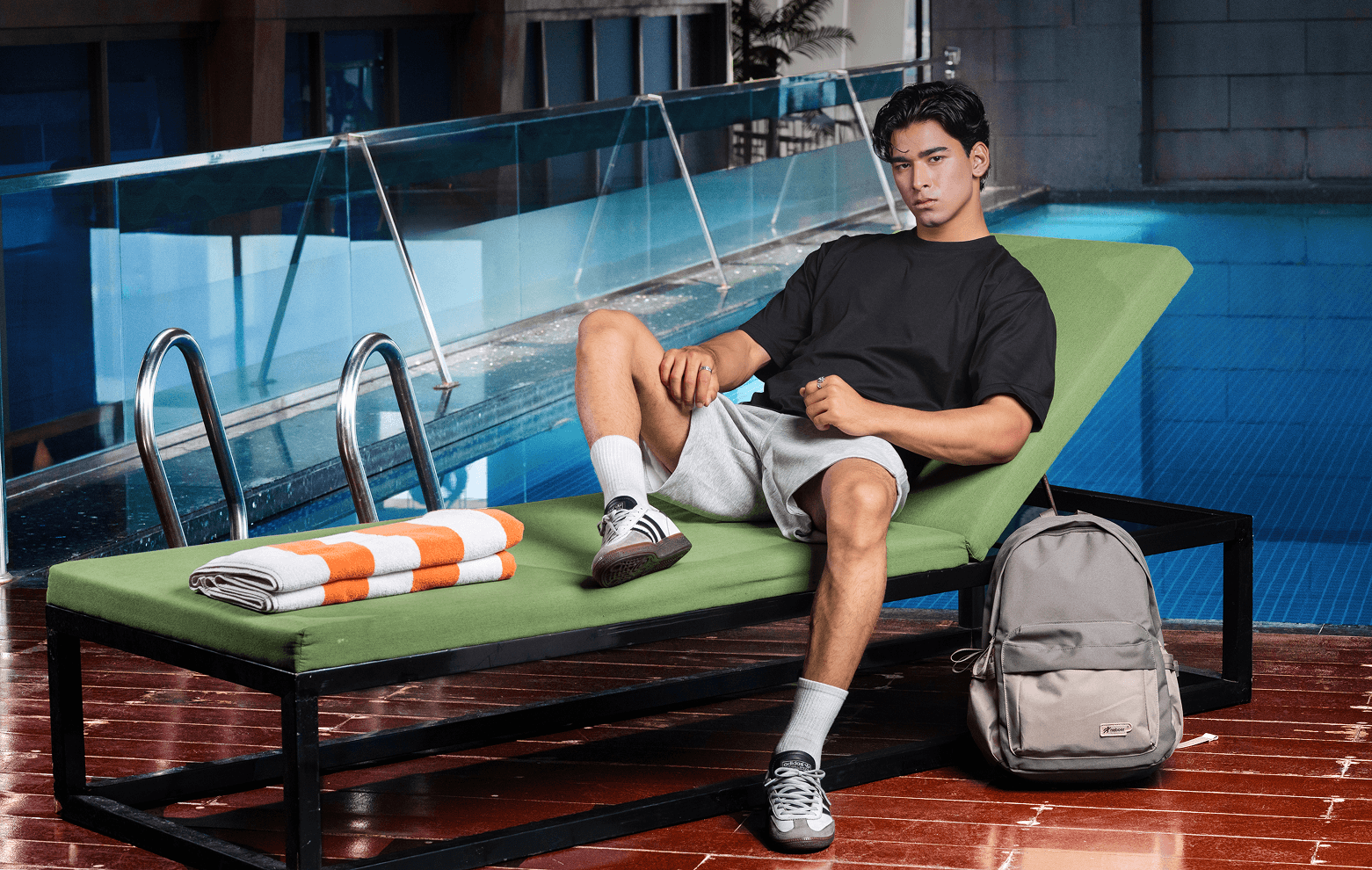 Model sitting poolside in black essentials